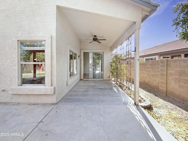 view of exterior entry with a patio area and ceiling fan