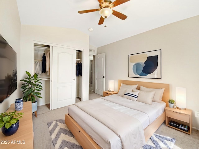 bedroom with a closet, vaulted ceiling, ceiling fan, and light carpet