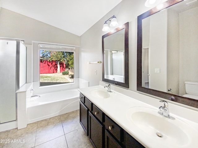 bathroom with tile patterned floors, vanity, separate shower and tub, and vaulted ceiling