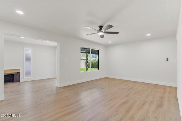 6908 E Windsor Ave, Scottsdale, AZ 85257 - spare room with light wood-style floors, a ceiling fan, a fireplace, and recessed lighting