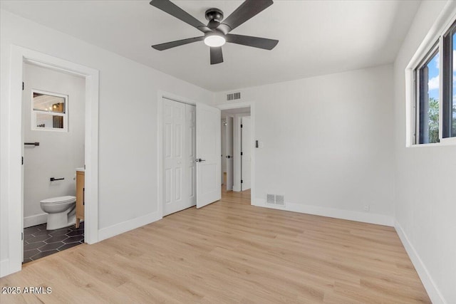 6908 E Windsor Ave, Scottsdale, AZ 85257 - unfurnished bedroom featuring light wood-type flooring, ensuite bathroom, a closet, and ceiling fan