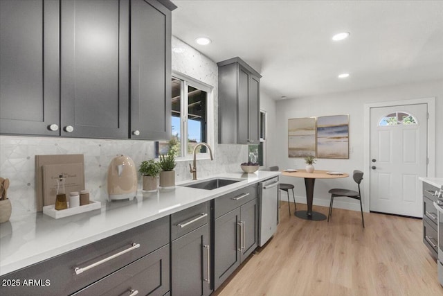 6908 E Windsor Ave, Scottsdale, AZ 85257 - kitchen with stainless steel dishwasher, light wood-style flooring, tasteful backsplash, light countertops, and recessed lighting