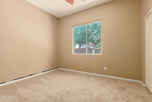 carpeted empty room featuring baseboards