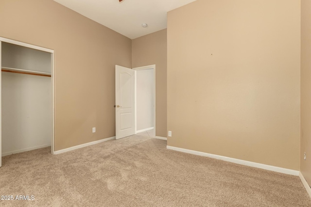 unfurnished bedroom with a closet, baseboards, and carpet flooring