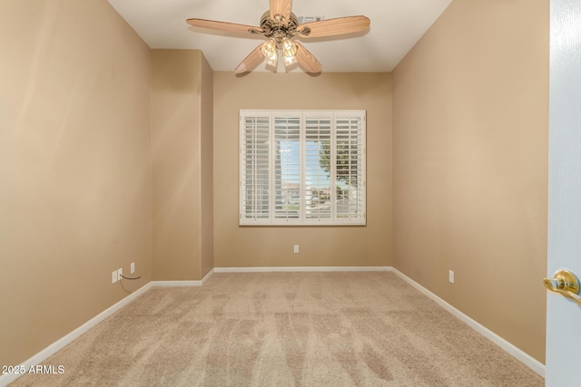 carpeted spare room featuring baseboards and ceiling fan