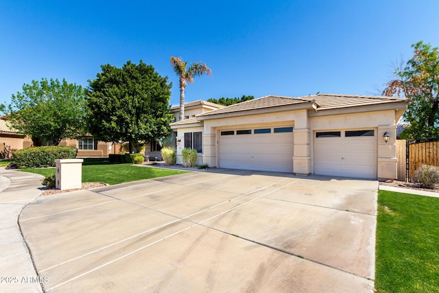 prairie-style house with a front lawn, concrete driveway, a tile roof, stucco siding, and a garage