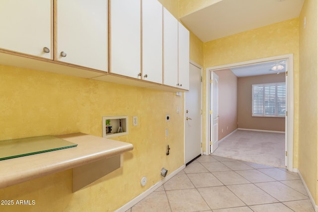 laundry area featuring hookup for a washing machine, light tile patterned floors, hookup for an electric dryer, gas dryer hookup, and cabinet space