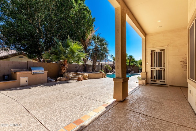 view of patio / terrace with a fenced backyard, a fenced in pool, and an outdoor kitchen