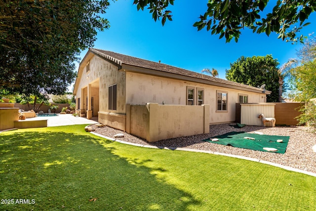 back of property with stucco siding, a lawn, a fenced backyard, and a patio area