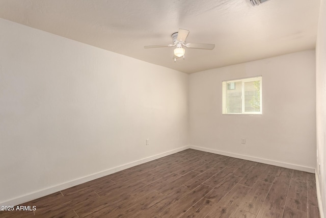 spare room featuring ceiling fan and dark wood-type flooring