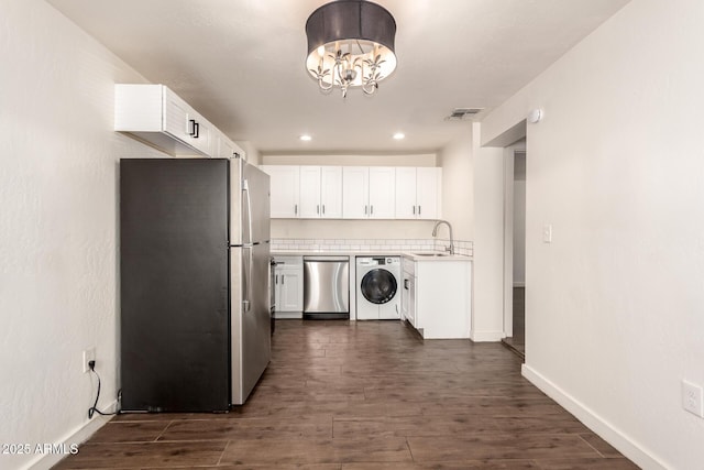 kitchen featuring white cabinetry, washer / clothes dryer, and appliances with stainless steel finishes