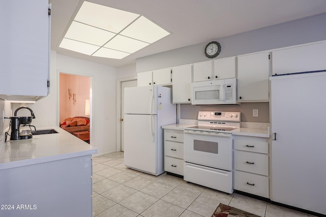 kitchen featuring white cabinets, light tile patterned flooring, white appliances, and sink