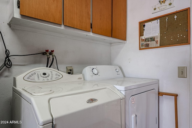 laundry area featuring washer and dryer and cabinets