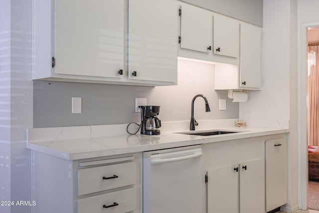 kitchen featuring white cabinetry, dishwasher, light stone countertops, and sink