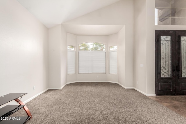 entryway with vaulted ceiling, french doors, and carpet