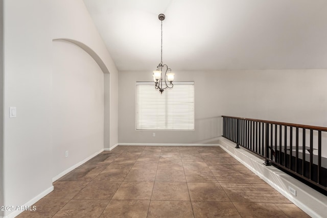 empty room with lofted ceiling, tile patterned floors, and a chandelier