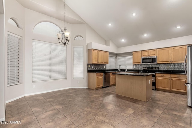 kitchen featuring sink, tasteful backsplash, a center island, hanging light fixtures, and appliances with stainless steel finishes