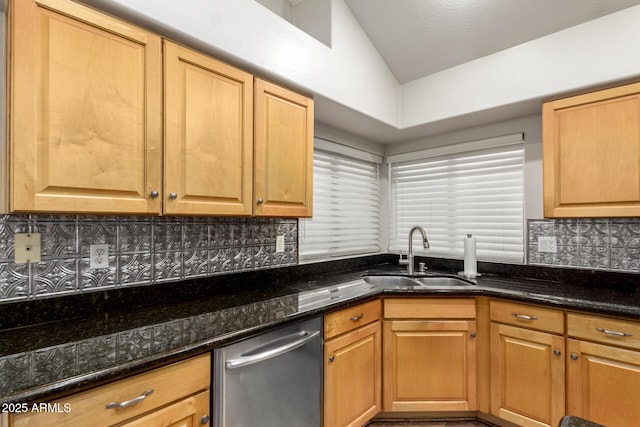 kitchen featuring sink, dark stone countertops, tasteful backsplash, vaulted ceiling, and stainless steel dishwasher