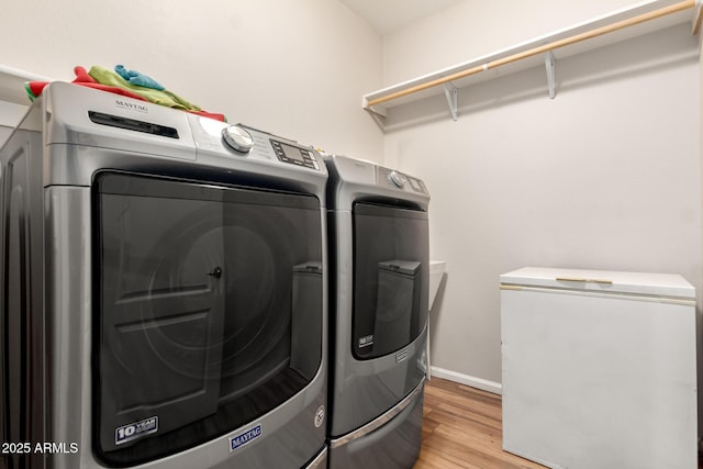 washroom with washer and clothes dryer and light wood-type flooring