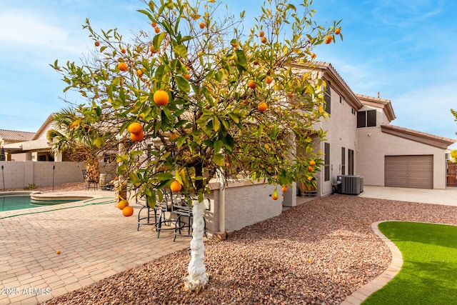 view of side of property featuring cooling unit, a fenced in pool, and a patio