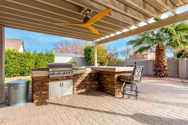 view of patio / terrace with ceiling fan, an outdoor kitchen, and grilling area