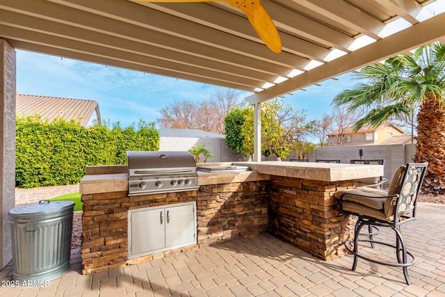 view of patio / terrace featuring a grill, ceiling fan, and exterior kitchen