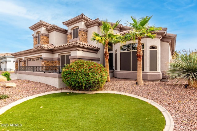 mediterranean / spanish-style house featuring a garage and a front yard