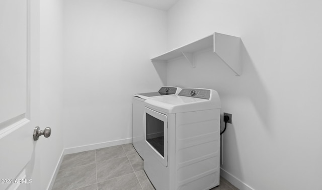 washroom featuring washer and clothes dryer and light tile patterned floors