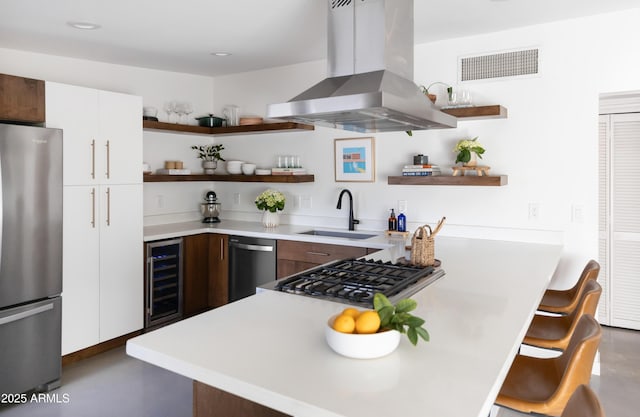 kitchen featuring white cabinetry, sink, beverage cooler, island exhaust hood, and appliances with stainless steel finishes