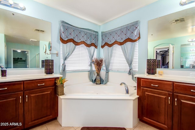 bathroom with a bath, visible vents, tile patterned flooring, and two vanities