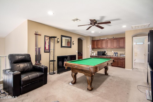 rec room featuring ceiling fan, arched walkways, visible vents, and light carpet