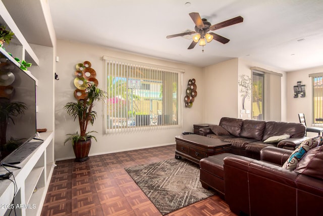 living room featuring ceiling fan and baseboards