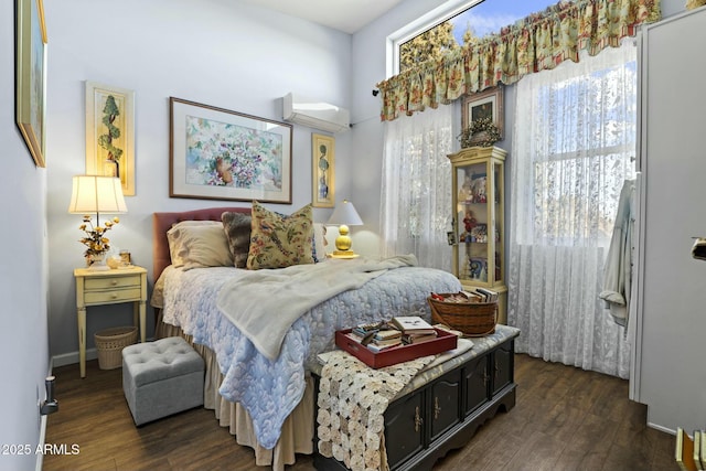 bedroom with dark wood-style floors and a wall mounted AC