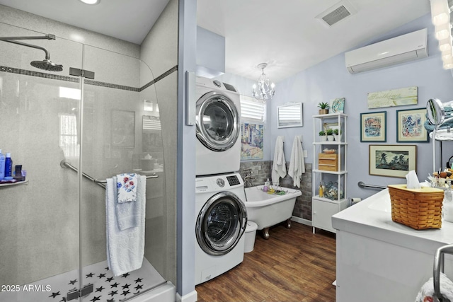 clothes washing area featuring stacked washer and dryer, laundry area, visible vents, dark wood-type flooring, and an AC wall unit