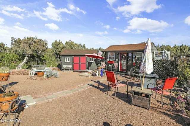 rear view of house with a storage shed and an outdoor structure