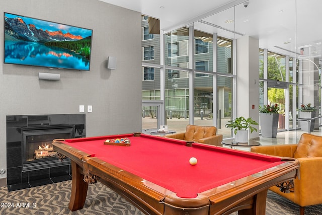 game room featuring floor to ceiling windows and a multi sided fireplace