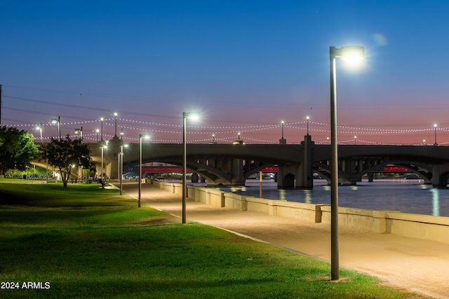 parking at dusk featuring a lawn