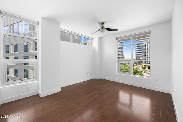 unfurnished room featuring dark wood-type flooring and ceiling fan