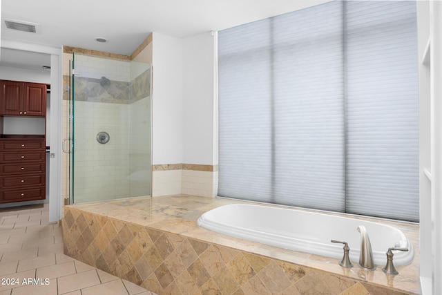 bathroom with tile patterned floors and shower with separate bathtub