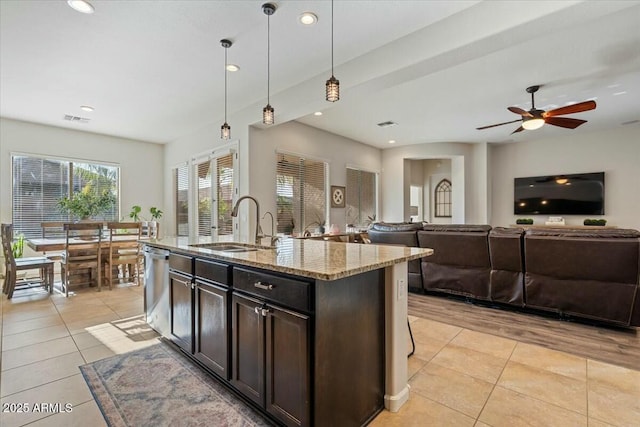 kitchen featuring visible vents, stainless steel dishwasher, light stone countertops, and light tile patterned floors