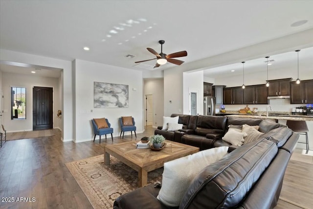 living area featuring visible vents, baseboards, a ceiling fan, recessed lighting, and light wood-style flooring