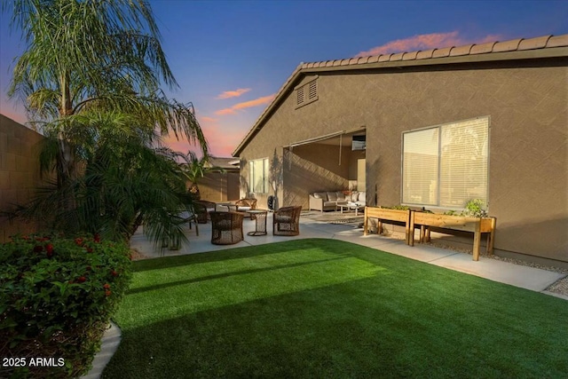 back of house featuring an outdoor hangout area, stucco siding, a lawn, a patio, and fence