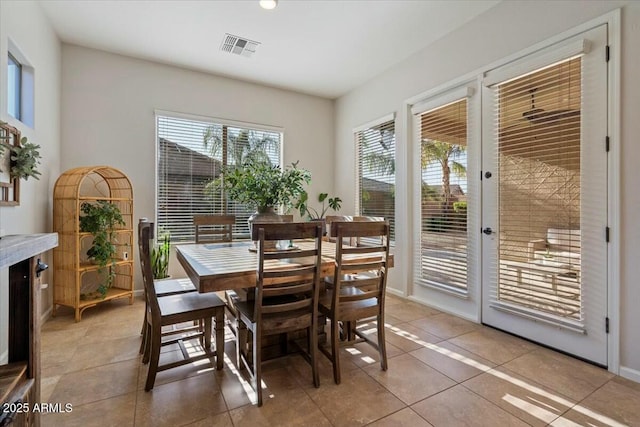 dining space featuring light tile patterned floors, visible vents, and baseboards