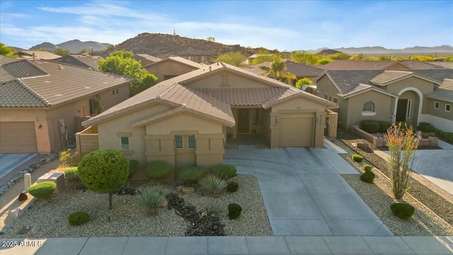 view of front of house featuring a tile roof, an attached garage, stucco siding, and concrete driveway