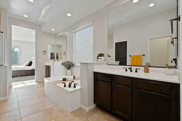 ensuite bathroom with recessed lighting, tile patterned flooring, ensuite bath, and a sink