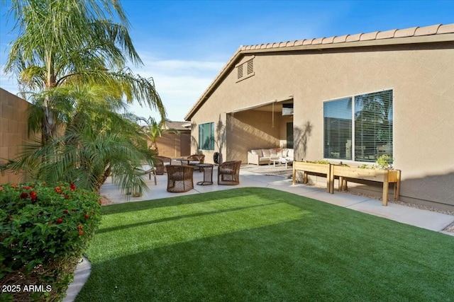 rear view of house featuring a fenced backyard, an outdoor living space, a lawn, and stucco siding
