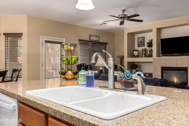 5735 S Cloverdale Ln, Gilbert, AZ 85298 - kitchen with open floor plan, a tiled fireplace, brown cabinetry, and built in features