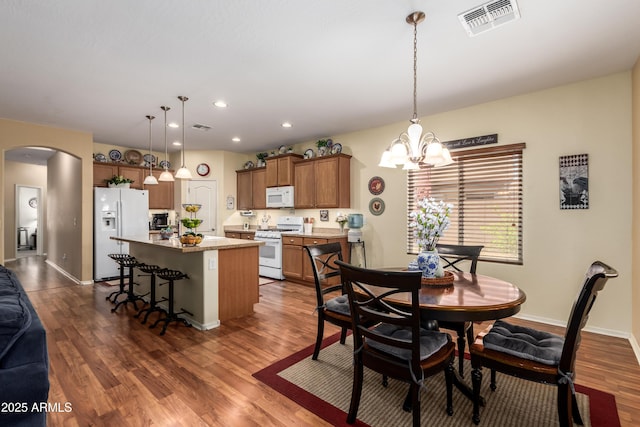 5735 S Cloverdale Ln, Gilbert, AZ 85298 - dining space featuring arched walkways, dark wood-style floors, a chandelier, and recessed lighting
