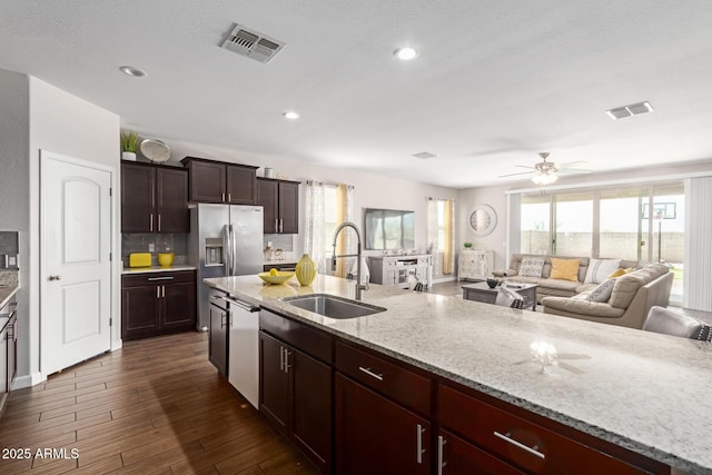 4108 N 304th Ln, Buckeye, AZ 85396 - kitchen featuring open floor plan, light stone countertops, appliances with stainless steel finishes, dark wood finished floors, and ceiling fan