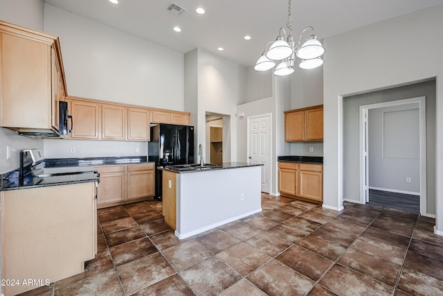 41208 W Bravo Dr, Maricopa, AZ 85138 - kitchen with black appliances, a towering ceiling, a chandelier, an island with sink, and baseboards